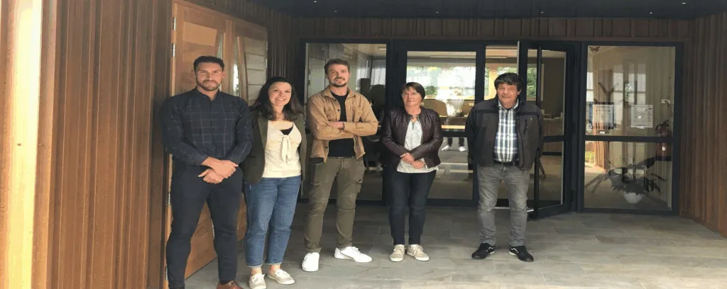 Équipe de conseillers funéraires professionnels accueillant les familles devant la chambre funéraire