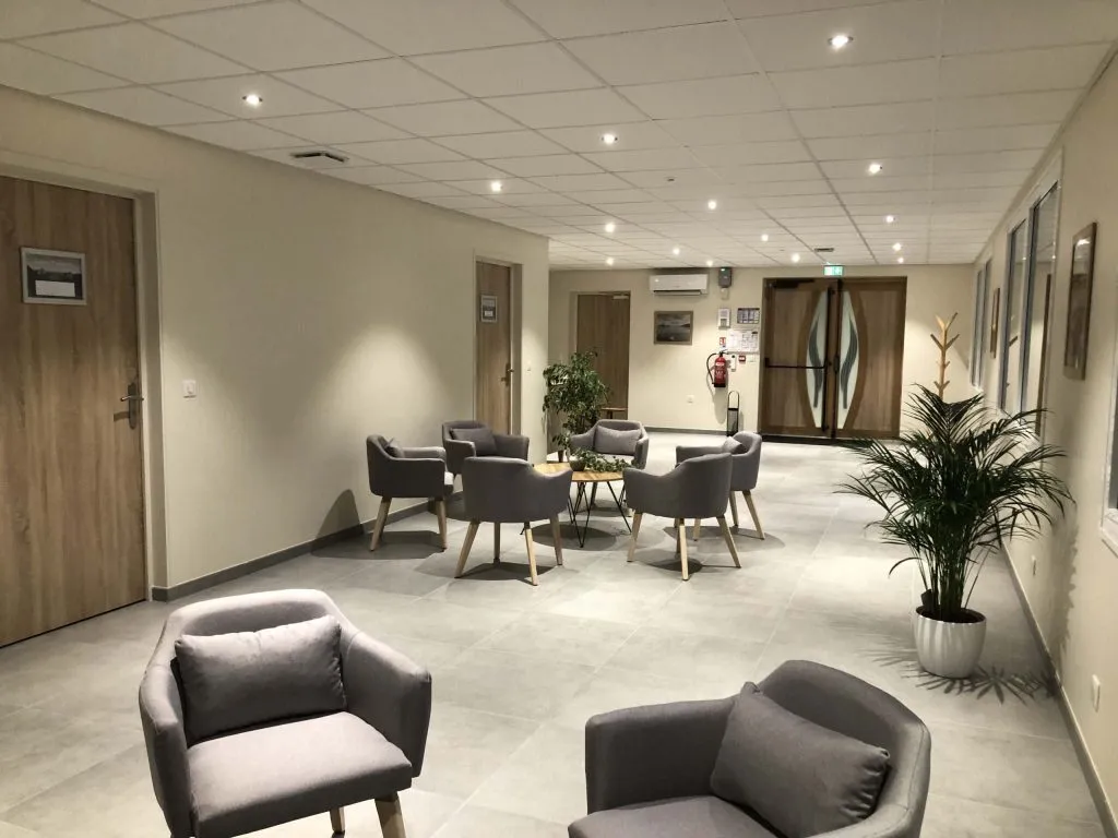 Espace d'accueil et salon d'attente chaleureux avec fauteuils confortables au sein du funérarium
